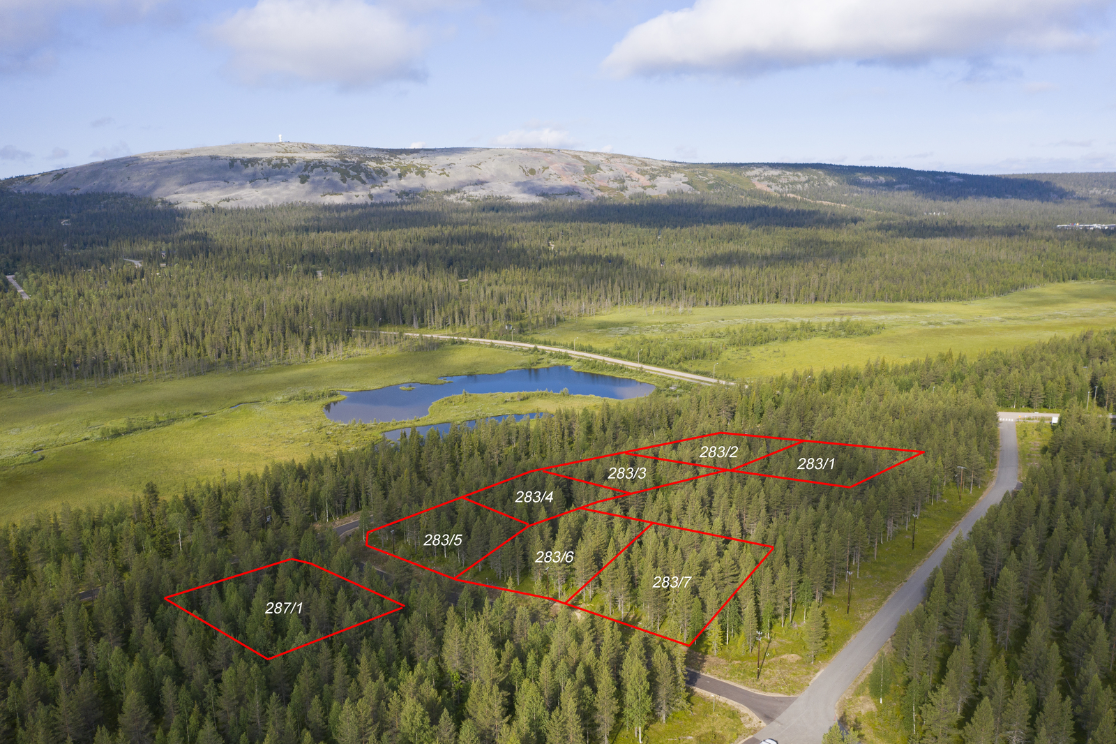 Kahdeksan tontin kaavat piirrettynä metsän ylle. Taustalla suo- ja tunturimaisema. Ilmakuva.