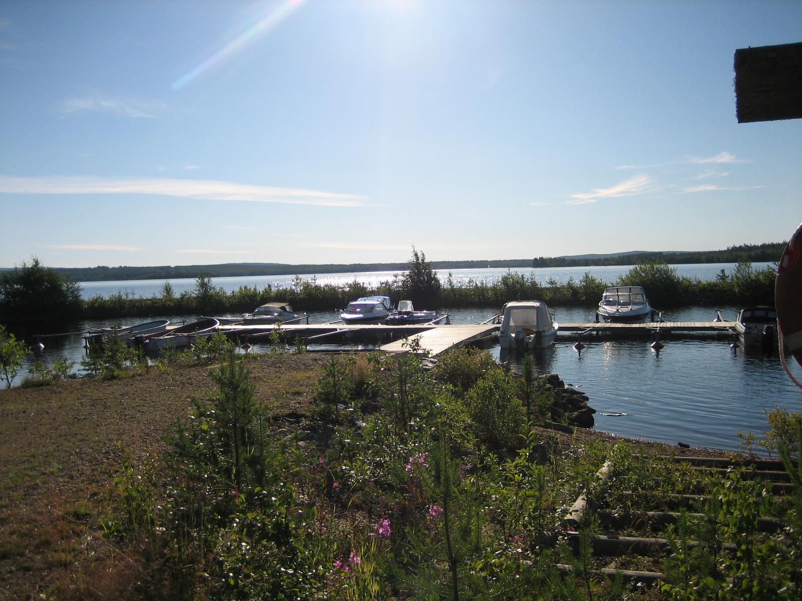 Kesäisessä järvimaisemassa etualalla on veneenlaskupaikka ja taustalla aallonmurtaja.