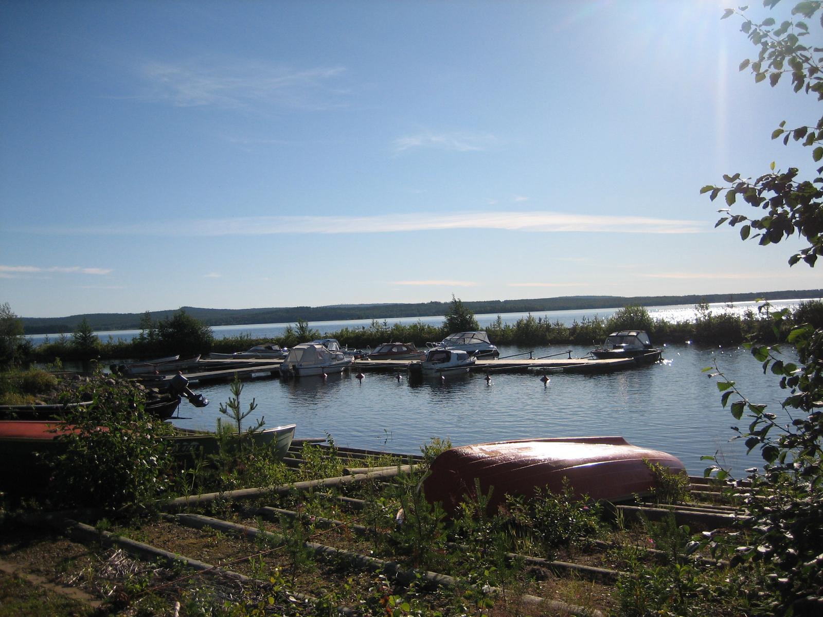 Venesatamassa olevien veneiden ja  aallonmurtajan takana avautuu laaja järvimaisema.