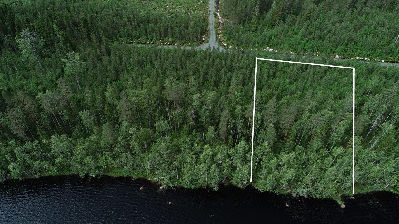 Tontin kaava piirrettynä metsään järven rantaan. Tie vie tontille. Ilmakuva.