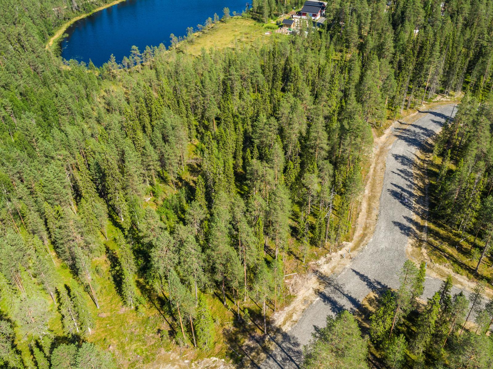 Ilmakuvassa tie haarautuu havumetsässä. Vasemmassa yläkulmassa pilkottaa vesistöä.