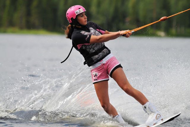 Wakeboard-harrastaja vauhdissa laudallaan järvellä.