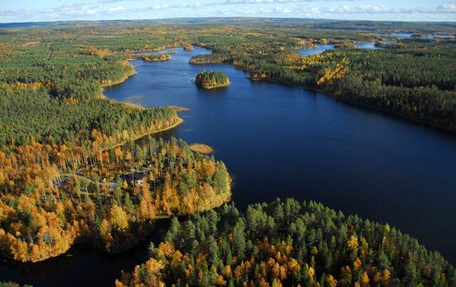 Syysmaisemassa metsien reunustama pitkulainen järvi ja Vihajoen suu. Ilmakuva.