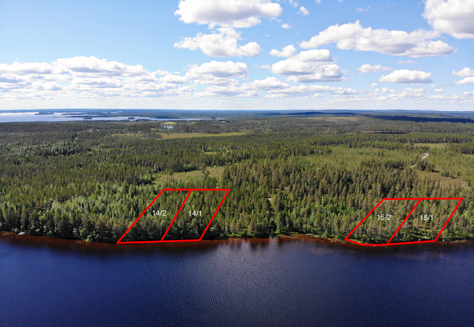 Neljän tontin kaavat piirrettynä metsään järven rantaan. Taivaalla on poutapilviä. Ilmakuva.