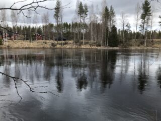 Tontilta avautuvassa jokimaisemassa vastarannalla on talo piharakennuksineen sekä koivikkoa.