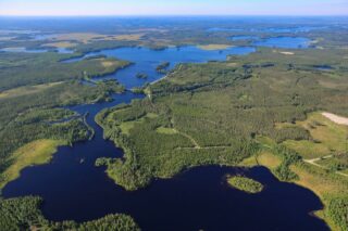 Aurinkoisessa ilmakuvassa järviä, jokia, soita ja metsää.