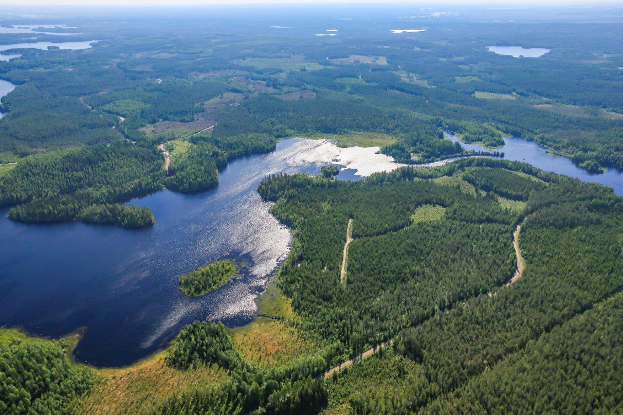 Aurinkoisessa ilmakuvassa järviä, jokia, soita ja metsää.