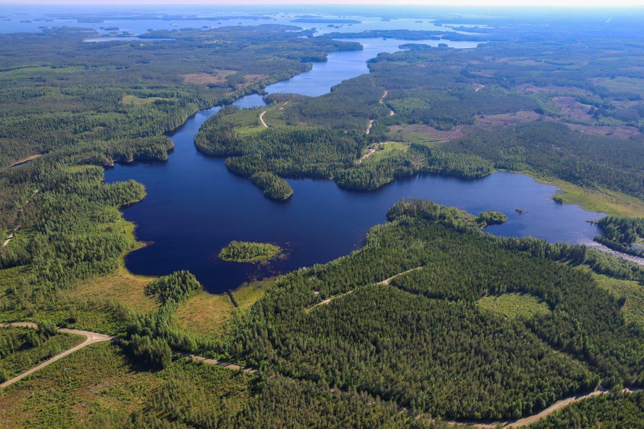 Aurinkoisessa ilmakuvassa järviä, jokia, soita ja metsää.